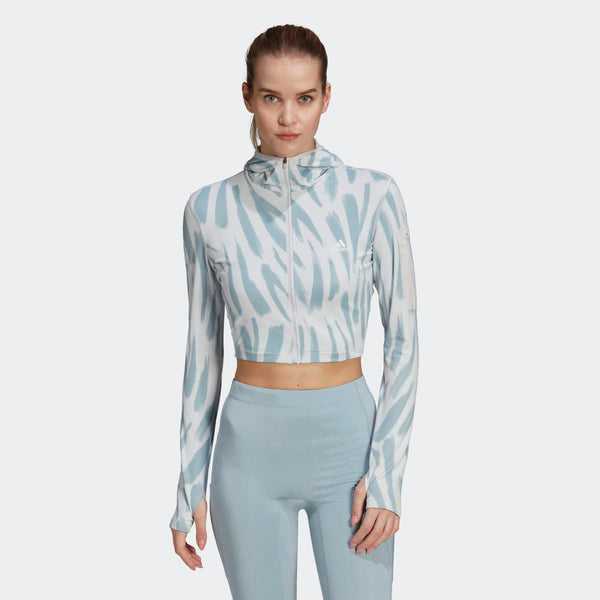 Adidas cropped running jacket with hood, light blue and white tiger stripe pattern.
