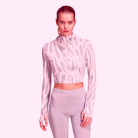 Woman in Adidas grey-patterned hooded crop top and leggings workout outfit.